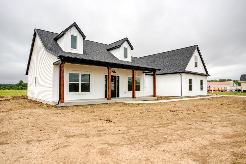 Modern farmhouse featuring a charming porch and contemporary design.