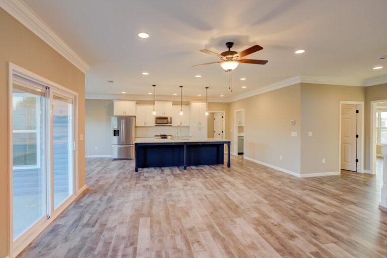 Bright open-concept living area with modern kitchen, hardwood floors, and natural light.