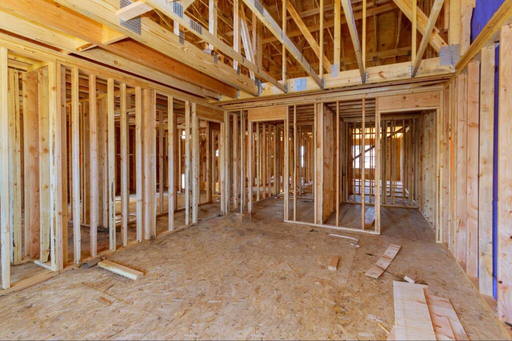 Framing in progress inside a modern construction site with wooden structures.