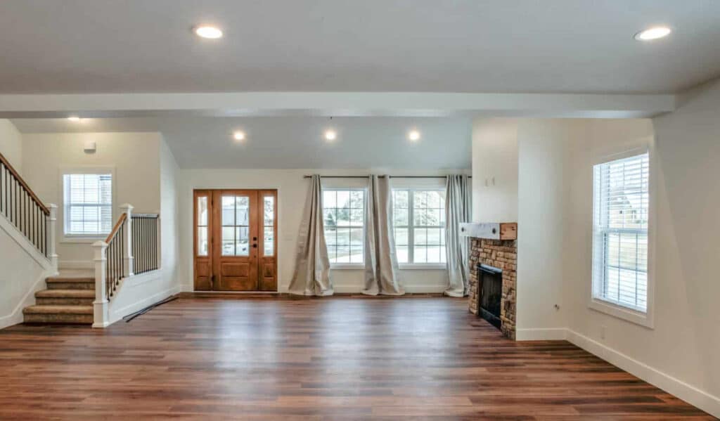 Spacious living room interior featuring large windows, hardwood floors, and modern design elements.