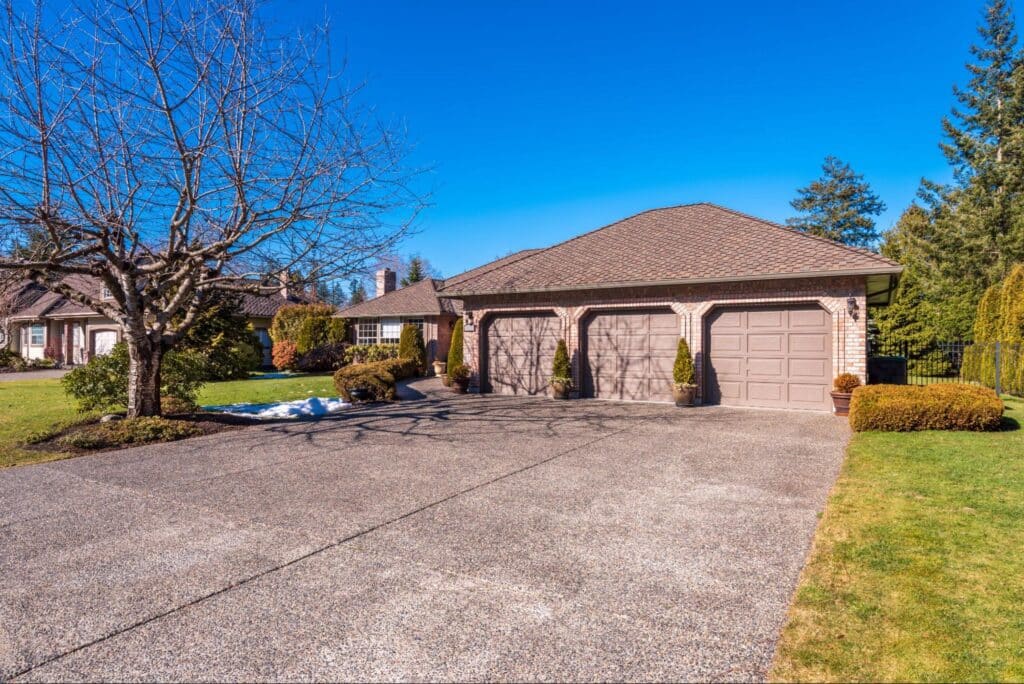 Spacious garage surrounded by trees under a clear blue sky.