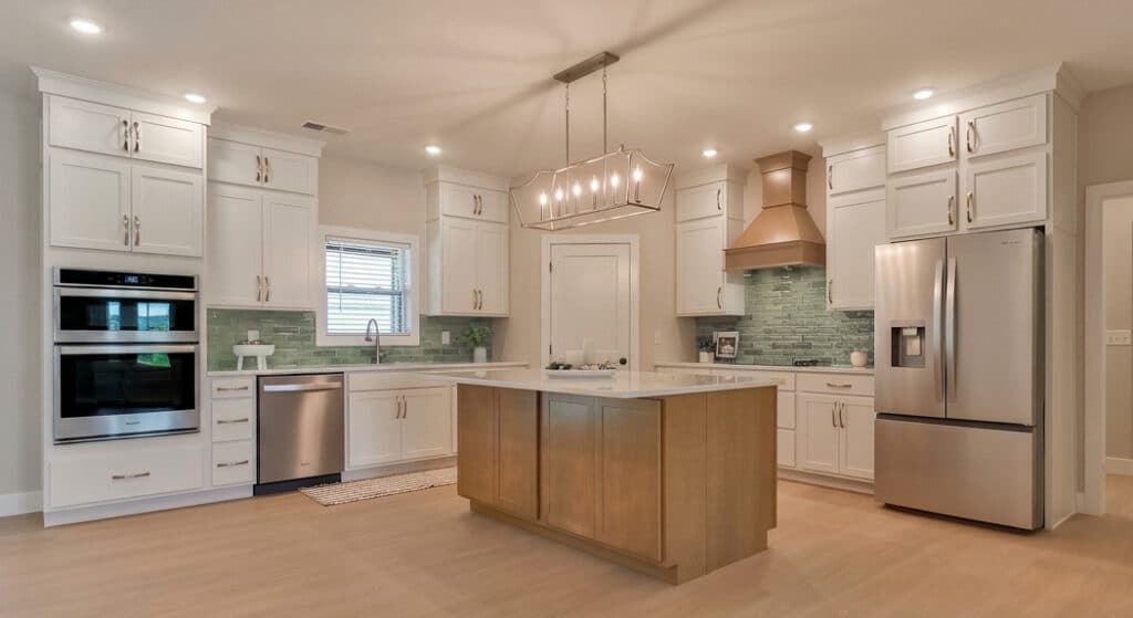 Modern kitchen design featuring white cabinets, green backsplash, and a central island.