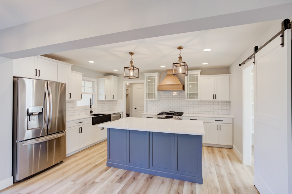 Stylish modern kitchen with white cabinets and a blue island, perfect for contemporary homes.