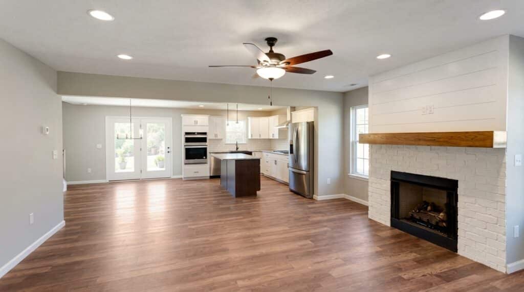 Spacious modern kitchen and living room with a cozy fireplace and stylish design.