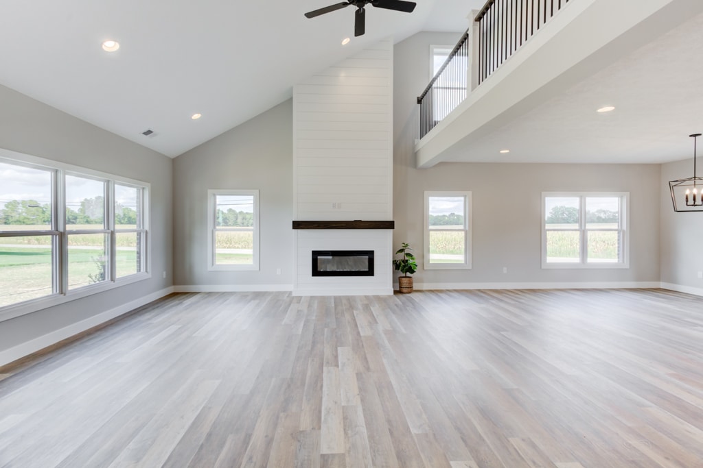 Spacious modern living room featuring a cozy fireplace and large windows.