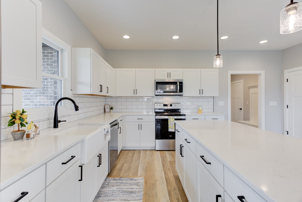 Bright and modern white kitchen with sleek cabinetry and stainless steel appliances.