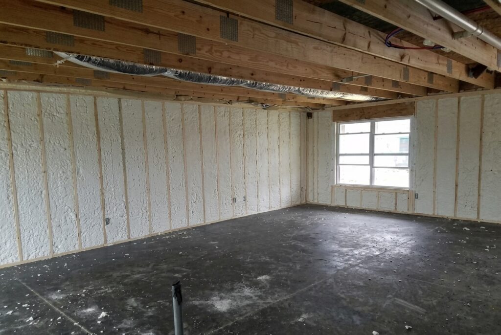 Unfinished room renovation with exposed insulation and floor ready for finishing touches.