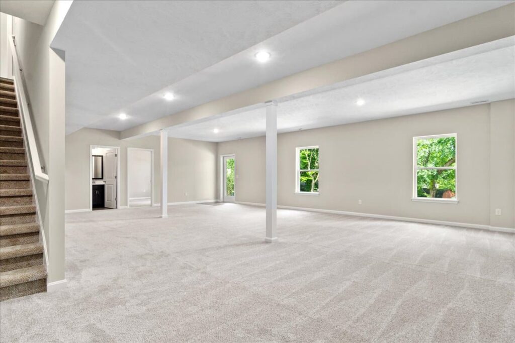 Spacious empty living room with natural light and plush carpet, ideal for customization.