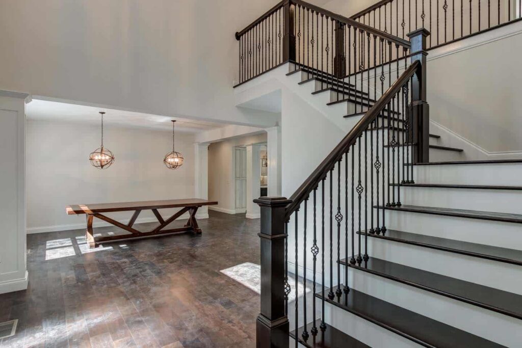 Elegant staircase design with modern railings and stylish lighting enhances the entryways appeal.